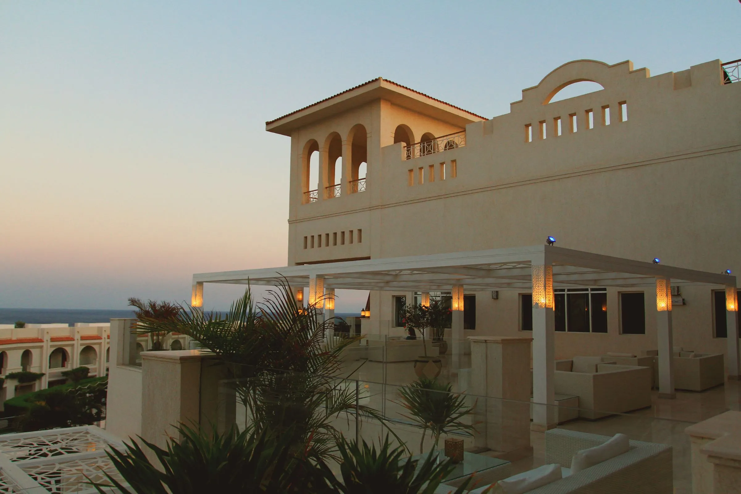A resort terrace at dusk with lanterns lit